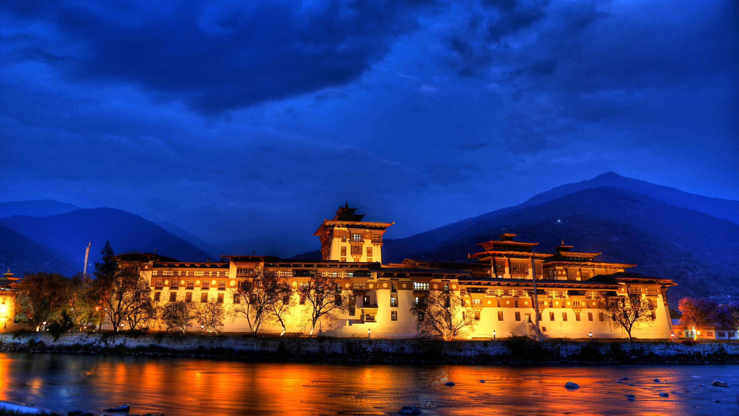 Punakha Suspension Bridge — prayer flags streaming over the Pho Chhu below Punakha Dzong